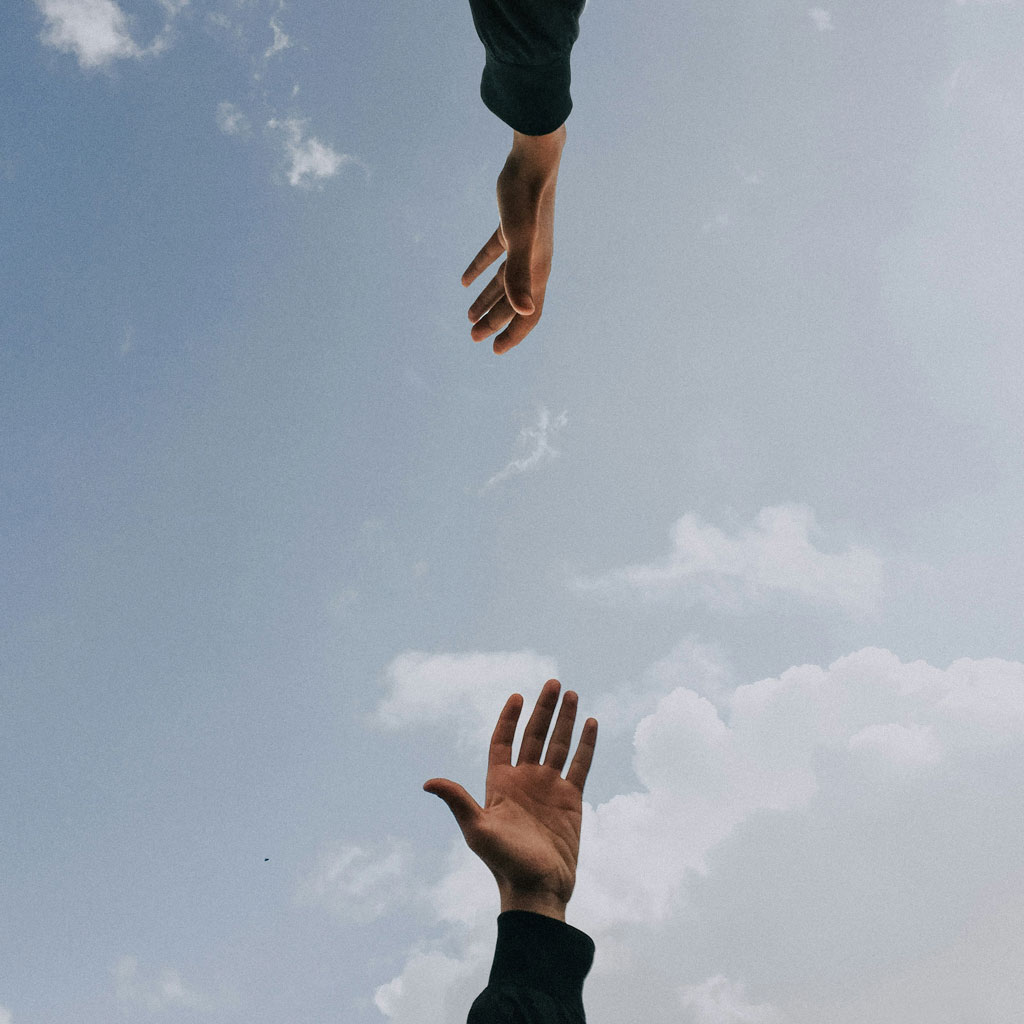 Two hands reaching towards each other.